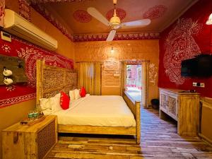 een slaapkamer met een bed met rode muren en een plafond bij Rani Mahal in Jodhpur