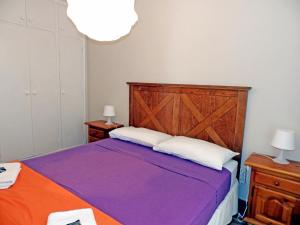 ein Schlafzimmer mit einem lila Bett mit zwei weißen Kissen in der Unterkunft Apartamentos Medano - Atico Playa in El Médano