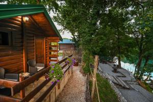 eine Hütte mit einer Veranda mit Blumen darauf in der Unterkunft Via river in Podgorica