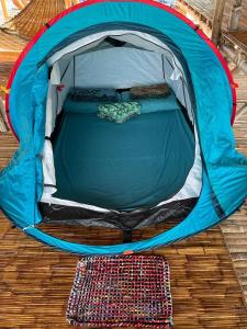 une tente bleue installée au-dessus d'un parquet dans l'établissement Bamboo Nest Beachfront Floating Tent, à Puerto Princesa