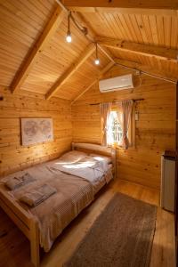 1 dormitorio con 1 cama en una cabaña de madera en Via river en Podgorica