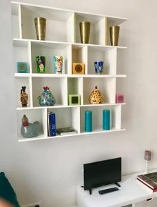 a room with white shelves with vases on them at Sweet Room 15 in Paris