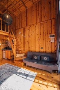 Habitación con sofá en una habitación de madera en SAPANCA KURUÇEŞME TINY HOUSE, en Sapanca