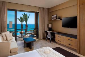 a hotel room with a bed and a desk with a television at Casa Maat at JW Marriott Los Cabos Beach Resort & Spa in San José del Cabo
