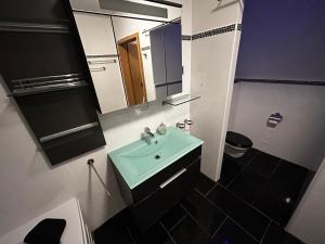 een badkamer met een groene wastafel en een spiegel bij Pension Günther in Graz