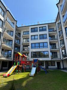 a playground in front of a apartment building at Apartament Nadmorski Zakątek Rowy in Rowy