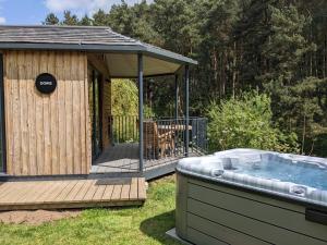 a hot tub on a deck with a gazebo at Riverside Cabins in Shrewsbury