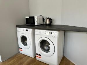 a kitchen with a washing machine and a counter at BLUE Hostel - Private Rooms by Friendly Hostel in Poznań