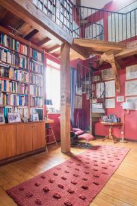 a room with a large library with a red rug at Villa Emma in Mavilly-Mandelot