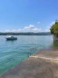 a boat in the water next to a dock at Lakeside holiday in Salò