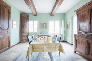 a dining room with a table and blue walls at Villa Emma in Mavilly-Mandelot