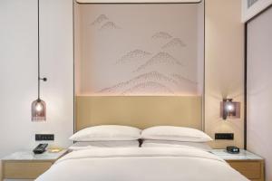 sypialnia z łóżkiem z dużym obrazem powyżej w obiekcie Courtyard by Marriott Foshan Gaoming w mieście Foshan