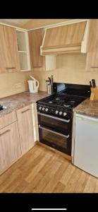 a kitchen with a black stove and wooden cabinets at Skegness Holidays at Haven in Skegness