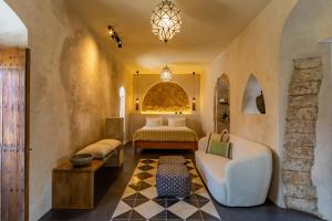 a bedroom with a bed and a couch and a table at The Riad - Adults Only in Tarifa