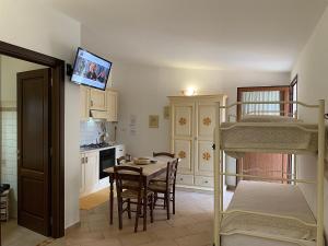a room with a dining table and a bunk bed at Agriturismo Vistamare in Orosei