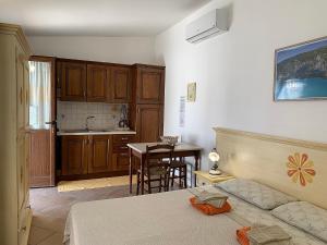 a bedroom with a bed and a kitchen with a table at Agriturismo Vistamare in Orosei