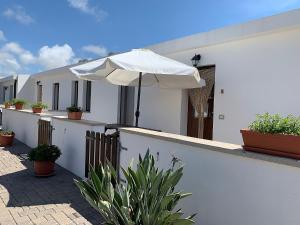 a white umbrella sitting on the side of a house at Agriturismo Vistamare in Orosei