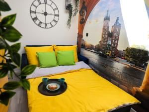 Una cama con una bandeja en ella con un reloj en la pared en Sander Apartments, en Cracovia