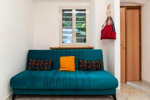 ein blaues Sofa mit gelbem Kissen in einem Zimmer in der Unterkunft Casa Vacanza Nibbio 26 in Sperlonga