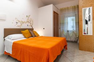 ein Schlafzimmer mit einem Bett mit einer orangefarbenen Decke in der Unterkunft Casa Vacanza Nibbio 26 in Sperlonga