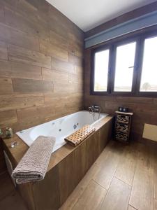 a large bathroom with a tub and wooden walls at Finca Marisa in Tinajo