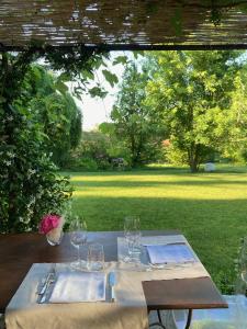 - une table avec des verres à vin et une cour dans l'établissement Locanda Maison Verte, à Cantalupa