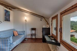 ein Wohnzimmer mit einem blauen Sofa und einem Fenster in der Unterkunft Bio - Vaglia in Vaglia
