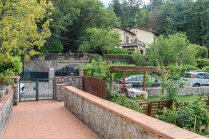 een stenen steunmuur met een poort in een tuin bij Bio - Vaglia in Vaglia