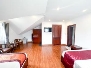 Habitación de hotel con 2 camas y mesa en White Horse Dalat Hotel en Dalat