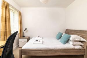 ein Schlafzimmer mit einem Bett mit blauen Kissen in der Unterkunft 2 Alexandra Court in St Andrews