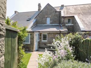 an old stone house with a garden in front of it at Middle Cottage in Amble