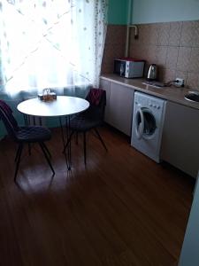 a kitchen with a table and a washing machine at Центр 95 квартала, Смарт-TV in Kryvyi Rih
