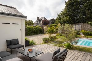 um quintal com uma piscina e uma casa em La Villa des Rochettes - Charmante maison avec piscine et jardin em Dinard