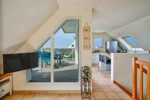 a kitchen with a sliding glass door leading to a deck at Ty Jamamo - Vue mer à 500m de la plage in Saint-Nic