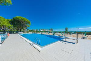 a swimming pool in a park with a blue sky at Park Residence Immobiliare Pacella in Lido di Jesolo