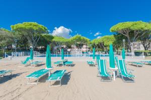 un grupo de sillas y sombrillas en una playa en Park Residence Immobiliare Pacella en Lido di Jesolo