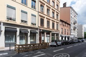 una strada cittadina con edifici e auto parcheggiati sulla strada di Le Select sur Cour - Havre de paix pour 2 à Lyon a Lione