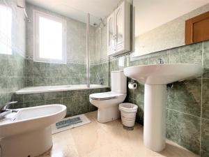 ein Badezimmer mit einem weißen Waschbecken und einer Toilette in der Unterkunft Gemelos 22-3-12 in Benidorm