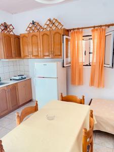 a kitchen with a table and a white refrigerator at Villa Privata a Cefalonia in Fársa