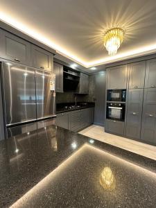 a kitchen with stainless steel appliances and a chandelier at SAPANCA ALHARRAN VILLA in Sapanca