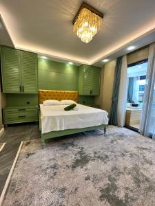 a bedroom with a bed with green walls and a chandelier at SAPANCA ALHARRAN VILLA in Sapanca +20 photos