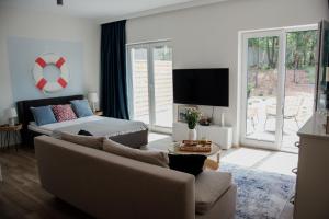 a living room with a couch and a tv at Stylowe apartamenty in Charzykowy