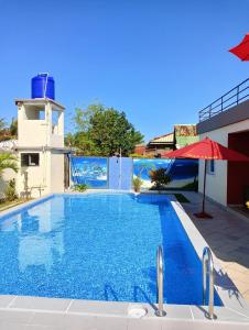 a large blue swimming pool next to a building at Villa de vacances privative in Toamasina