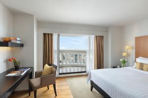 a hotel room with a bed and a desk and a window at lebua at State Tower in Bangkok