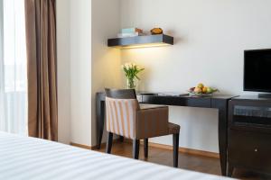 a hotel room with a desk and a chair at lebua at State Tower in Bangkok