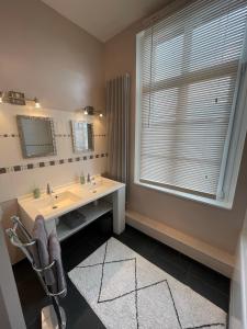 a bathroom with a sink and a mirror and a window at Le Logis d’Anne-Sophie in Chuignolles