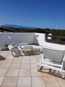 ein Paar Stühle und ein Tisch auf einer Terrasse in der Unterkunft Villa Cala d'Oro santa teresa di gallura in Santa Teresa Gallura