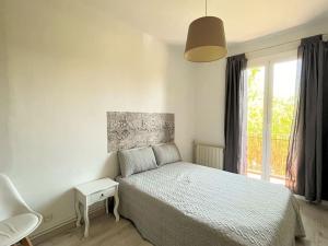 a white bedroom with a bed and a window at Apartamento muy luminoso frente a Parque Joan Miró in Barcelona