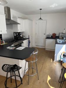 a kitchen with a black counter and stools in it at Number 33 Family Beach Residence in Great Yarmouth