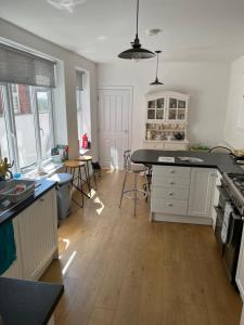 a kitchen with white cabinets and a wooden floor at Number 33 Family Beach Residence in Great Yarmouth